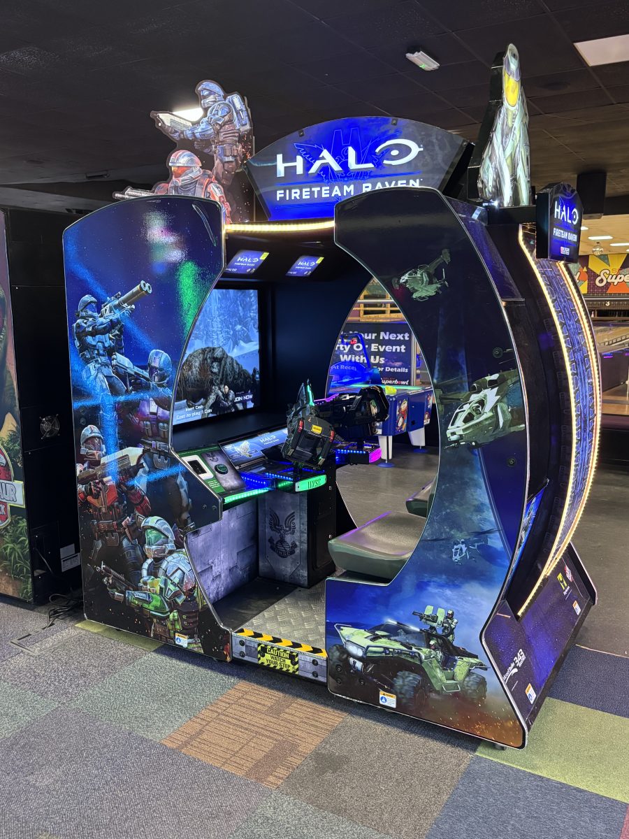 Halo: Fireteam Raven arcade cabinet with blue, futuristic walls and character artwork on panels behind the screen area.